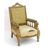 A Victorian carved oak armchair with a shaped cresting rail, carved frame and lions mask arm