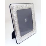An Italian photograph frame with easel back and white metal surround with acanthus scroll