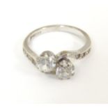 A 9ct white gold crossover ring with twin round cut white stones with further smaller white stones
