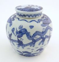 An Oriental blue and white ginger jar decorated with a landscape scene with a dragon dance