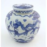 An Oriental blue and white ginger jar decorated with a landscape scene with a dragon dance