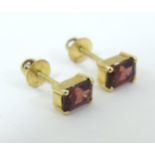 A pair of 14ct gold stud earrings set with garnets (matching to lot 583) Please Note - we do not