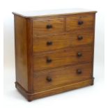 A Victorian mahogany chest of drawers with a moulded top above two short over three long drawers
