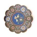 An Oriental cloisonne charger with scalloped rim with lily flower detail to centre and fish scale