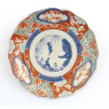 A Japanese plate decorated in the Imari palette with stylised flowers and foliate detail.