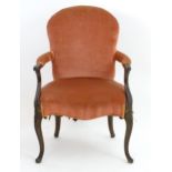 A late 18thC mahogany open armchair with a shaped backrest and swept arms above cabriole legs. 24"