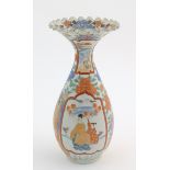 A Japanese vase with a flared rim and scalloped edge, decorated with two figures in a landscape with