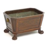 A Regency mahogany wine cooler with canted corners, a lead interior and flanked by lions mask ring