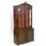 A French 19thC bookcase / cabinet with a moulded carved pediment above two glazed doors and two