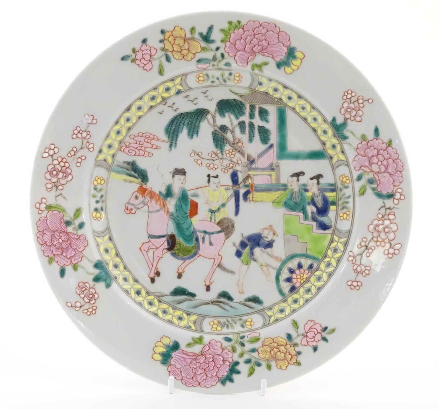 A Chinese famille rose plate depicting a landscape scene with a figure on horse back with an