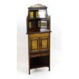 An early 20thC rosewood corner cupboard with a mirrored top section flanked by turned finials and
