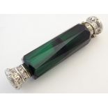 A Victorian green glass two sectional, double ended scent bottle with white metal mounts. 5" long