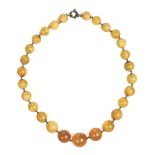 * Amber. Early 20th-century string of butterscotch amber beads