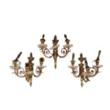 A SET OF FOUR GILT BRONZE AND CUT GLASS THREE LIGHT WALL APPLIQUES,