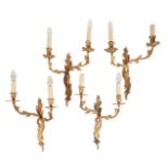 A SET OF FOUR GILT METAL TWIN LIGHT WALLL APPLIQUES, IN LOUIS XV TASTE,