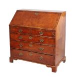 A WALNUT AND FEATHER BANDED BUREAU IN GEORGE II STYLE,