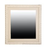 A CARVED AND WHITE PAINTED WOOD FRAMED WALL MIRROR,
