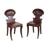 A PAIR OF GEORGE IV CARVED MAHOGANY HALL CHAIRS, IN THE MANNER OF GILLOWS,