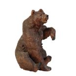 A 'BLACK FOREST' CARVED AND STAINED LINDEN WOOD MODEL OF A BEAR,