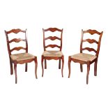 A SET OF EIGHT STAINED BEECH AND RUSH SEATED LADDER BACK CHAIRS,