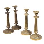 A MATCHED SET OF FOUR RESTAURATION GILT METAL CANDLESTICKS,