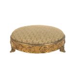 AN EARLY VICTORIAN REPOUSSE ORMOLU AND UPHOLSTERED FOOTSTOOL,