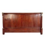 AN EMPIRE MAHOGANY AND ORMOLU MOUNTED HEADBOARD,