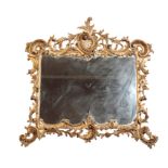 A CARVED AND GILTWOOD FRAMED WALL MIRROR IN ROCOCO STYLE, PROBABLY ITALIAN,