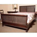 A CARVED MAHOGANY AND CANEWORK DOUBLE BED, BY HEAL & CO.,