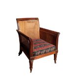 A REGENCY MAHOGANY AND CANEWORK LIBRARY BERGERE ARMCHAIR, IN THE MANNER OF GILLOWS,