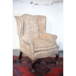 A VICTORIAN CARVED WALNUT AND UPHOLSTERED WINGBACK ARMCHAIR IN GEORGE I STYLE,