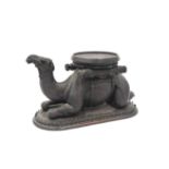 AN ANGLO INDIAN CARVED ROSEWOOD BOTTLE COASTER IN THE FORM OF A RECUMBENT CAMEL,