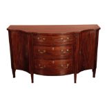 A GEORGE III MAHOGANY SERPENTINE FRONT COMMODE, IN THE MANNER OF GILLOWS,