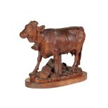 A FINE 'BLACK FOREST' CARVED AND STAINED LINDEN WOOD MODEL OF A COW,