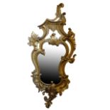 AN EARLY 19TH CENTURY CARVED AND GILTWOOD FRAMED WALL MIRROR, IN ROCOCO REVIVAL STYLE,