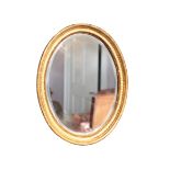 A PAIR OF GILTWOOD AND COMPOSITION FRAMED OVAL WALL MIRRORS,