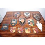 A GROUP OF TWELVE VARIOUS PAINTED PLASTER, WOOD AND METAL ARMORIAL PANELS,