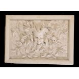 AN ITALIAN MOULDED PLASTER RELIEF PANEL DEPICTING A GROTESQUE MASK,