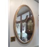 AN EDWARDIAN OVAL GILT FRAMED MIRROR