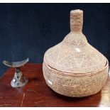 A WOVEN SNAKE CHARMER'S BASKET WITH LID and a carved tribal wooden headrest (2)