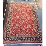 A RED GROUND PERSIAN DESIGN RUG