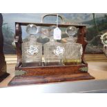 AN EDWARDIAN THREE BOTTLE OAK TANTALUS