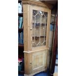 A STRIPPED PINE CORNER CABINET