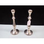 A PAIR OF WHITE METAL CANDLESTICKS