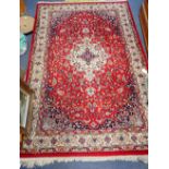 A RED GROUND PERSIAN DESIGN RUG