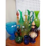A COLLECTION OF COLOURED GLASS EWERS