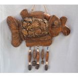 A CARVED WOOD AND POTTERY SHERD EMBELLISHED WIND CHIME