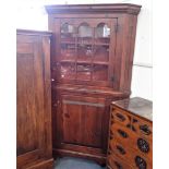 A CONTINENTAL STAINED PINE CORNER CUPBOARD