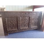 A 17TH CENTURY OAK COFFER WITH PROFUSELY CARVED FRONT