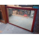 A LARGE MIRROR, IN VELVET COVERED FRAME